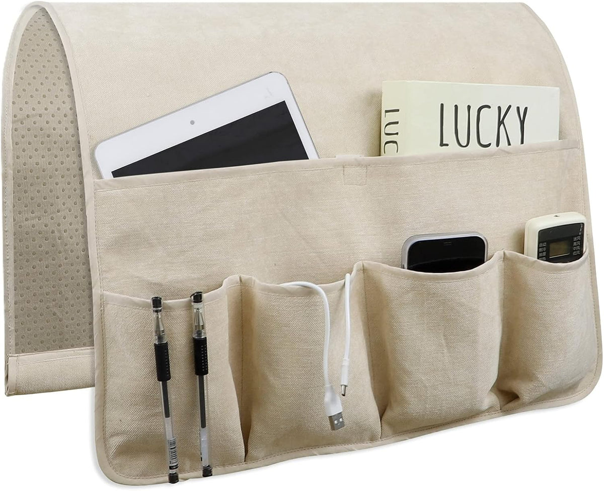 Beige linen organizer laid flat showing dotted non-slip inner lining and pockets holding pens and remotes