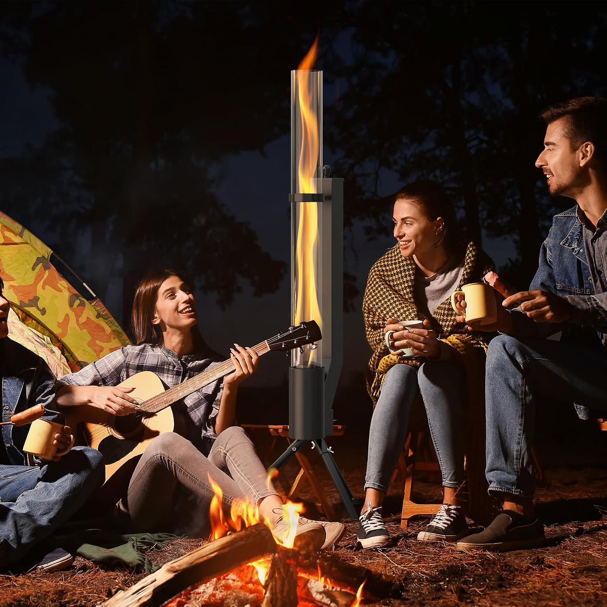 Group of friends seated around a campfire with the tall glass-tube pellet heater glowing between them at night.