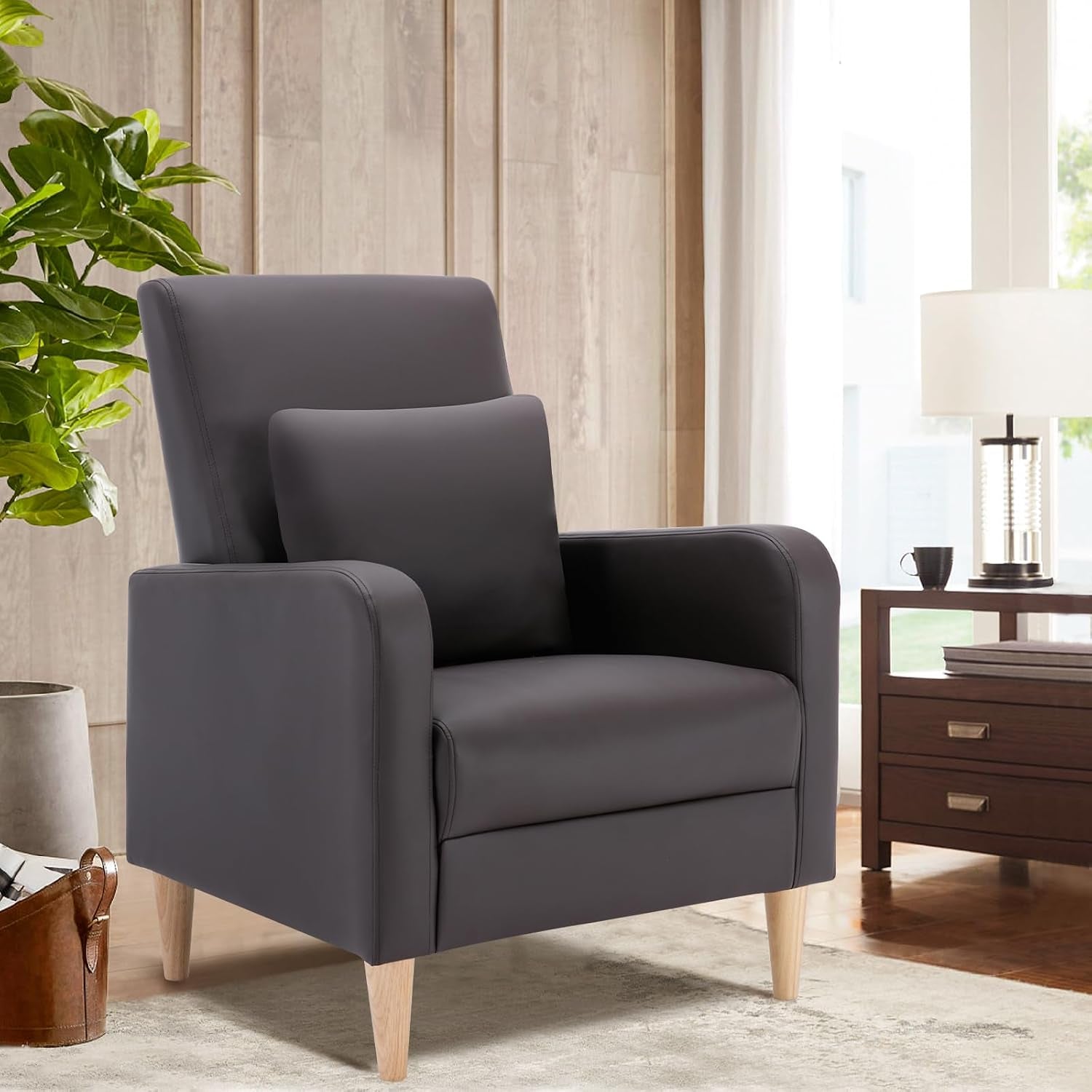Single dark gray accent chair with matching lumbar pillow and light wood legs beside a nightstand