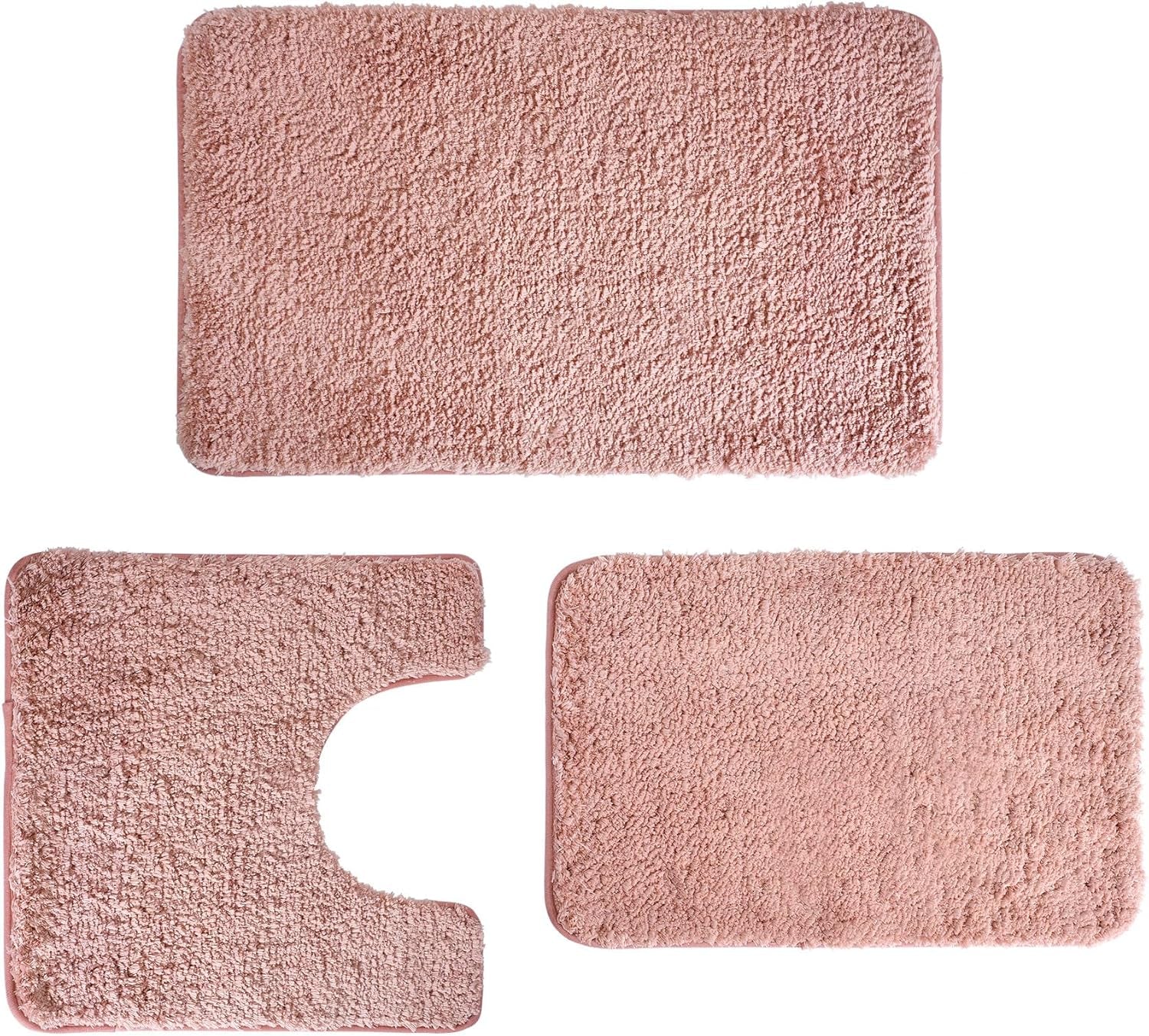 Three-piece bathroom rug set in dusty pink shown flat: rectangular bath mat, U-shaped contour rug, and matching small mat.