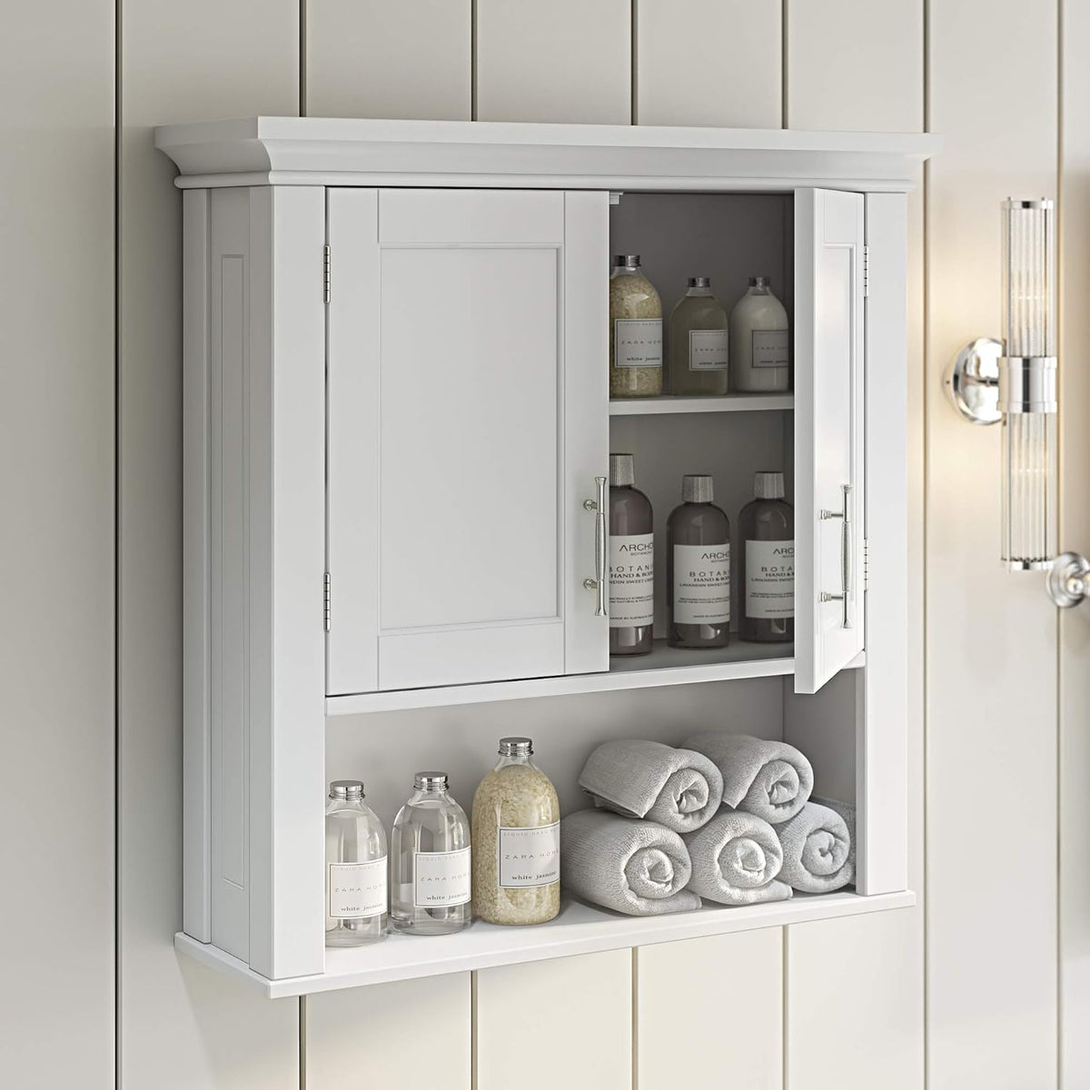 Wall-mounted white cabinet in a bathroom with one door open showing interior adjustable shelf and toiletries