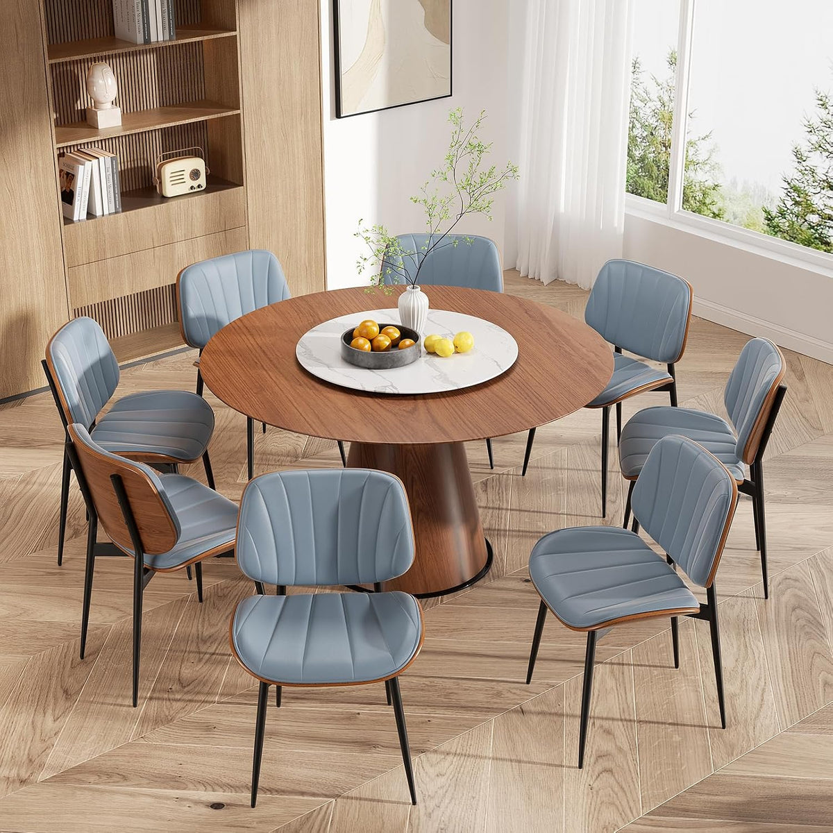 Overhead room view of a round walnut table surrounded by blue faux-leather dining chairs with bentwood backs.