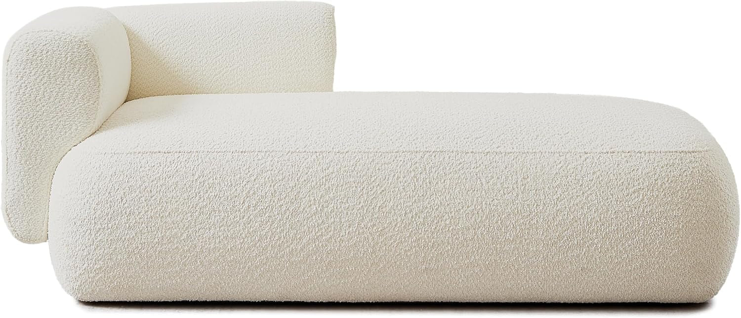 Side profile of cream boucle chaise showing low back, rounded seat silhouette and wood legs