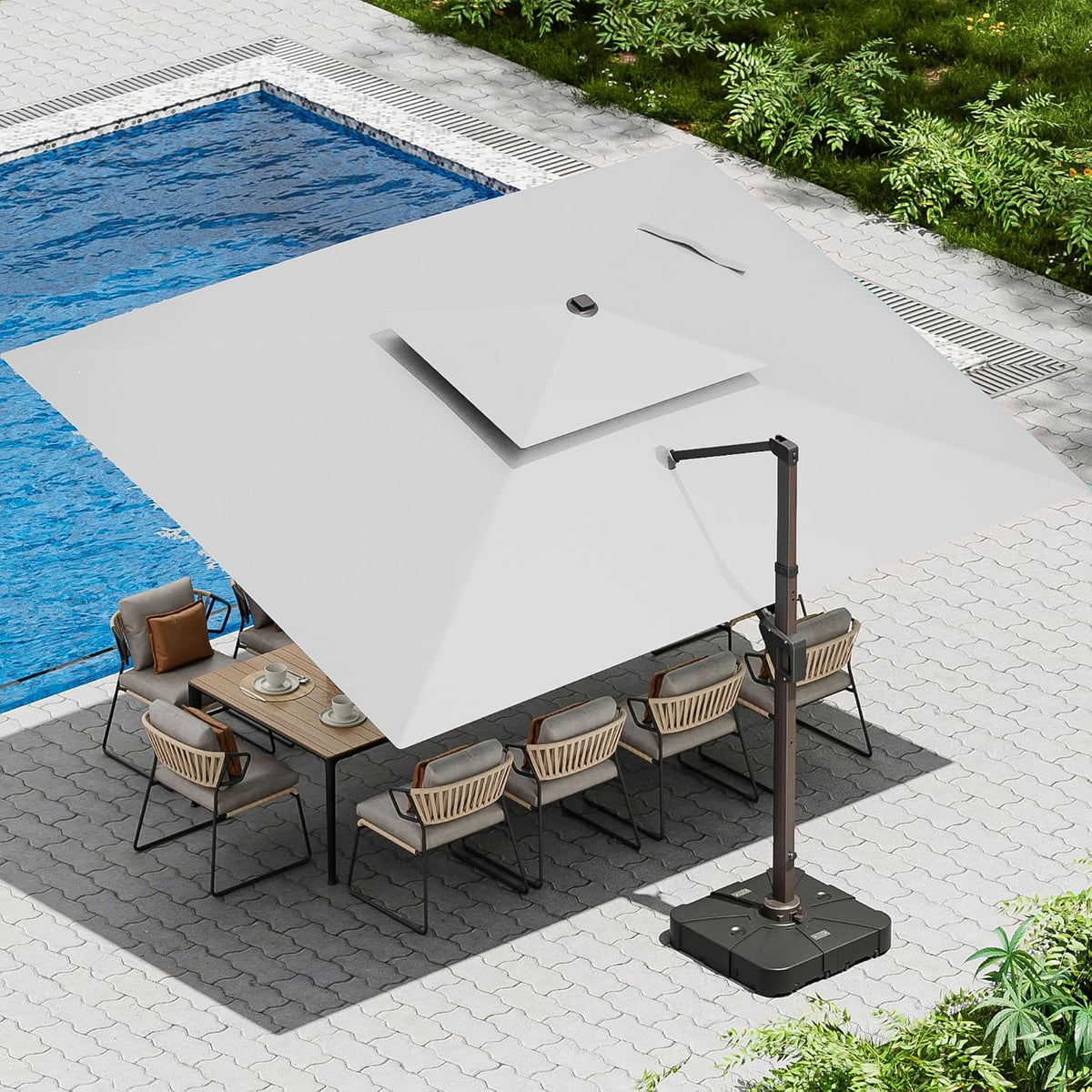 Aerial view of a large offset umbrella shading a dining table beside a pool with brown base.
