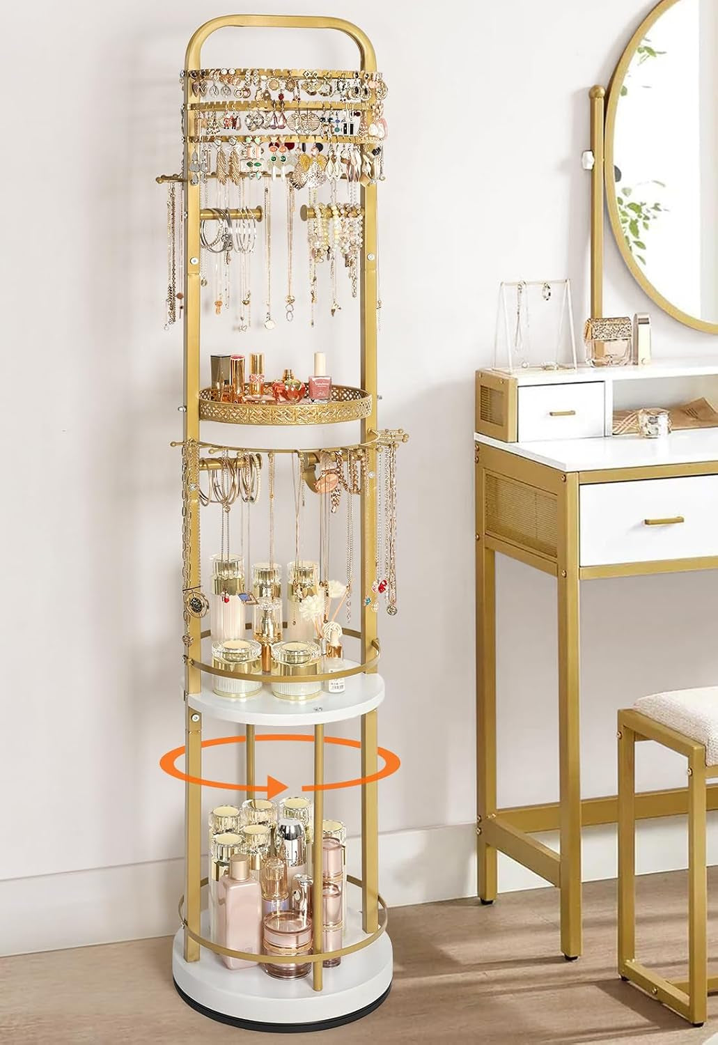 Gold freestanding rotating jewelry organizer displaying necklaces, earrings and bottles beside a gold-accent vanity.