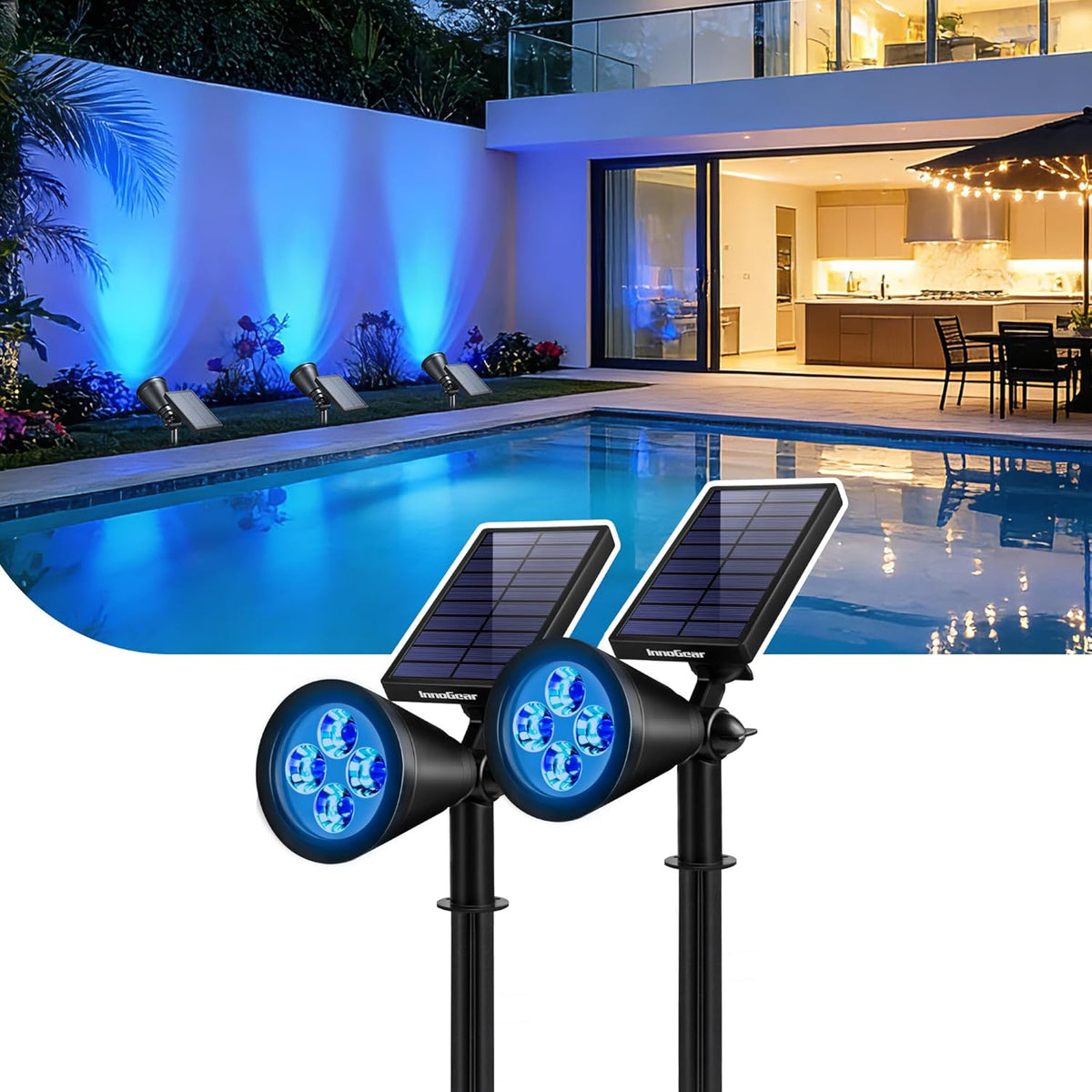 Two solar spotlights shown near a pool casting blue light on a wall and plants at night