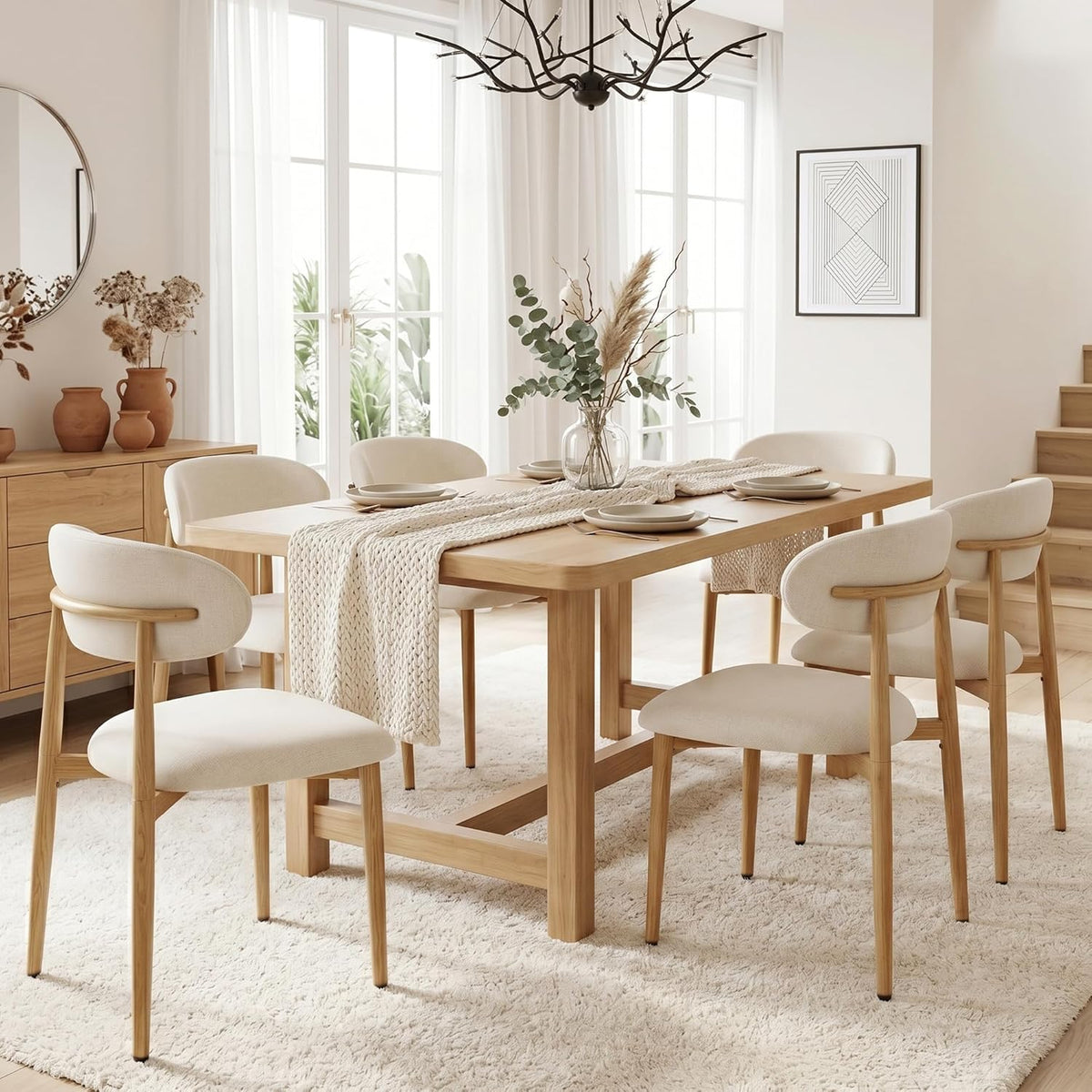 Beige upholstered dining chairs around a rectangular wood dining table on a textured rug in a bright dining room