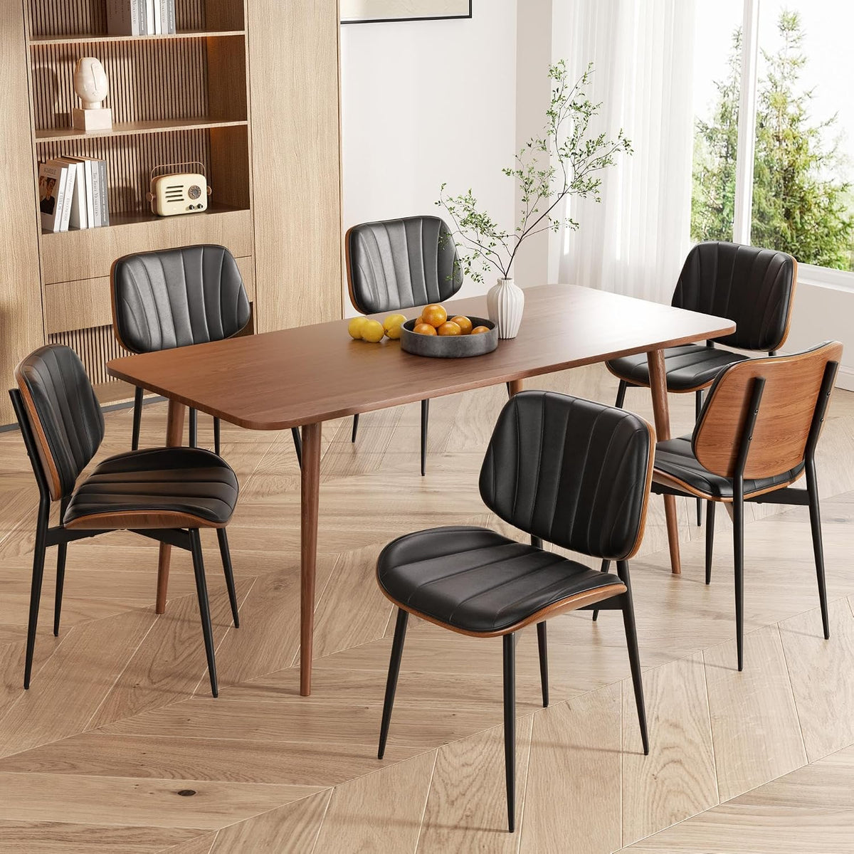 Rectangular walnut dining table set with black faux-leather chairs showing the bentwood back detail.