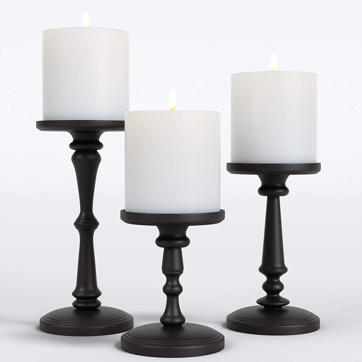Matte black metal pillar candle holders set of three with white pillar candles, front view