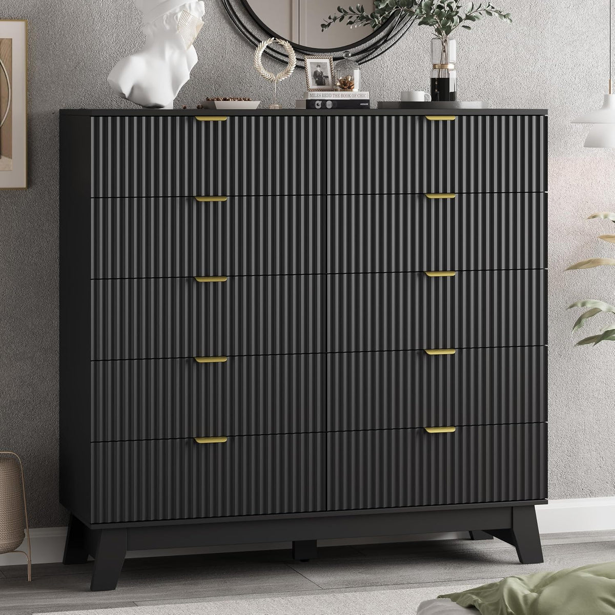 Tall black wave-panel dresser with gold recessed handles in a bedroom setting