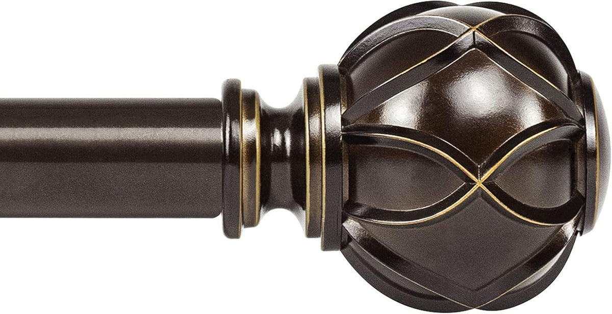 Close-up of a bronze-finish curtain rod end with a carved spherical finial and thin gold accent lines.