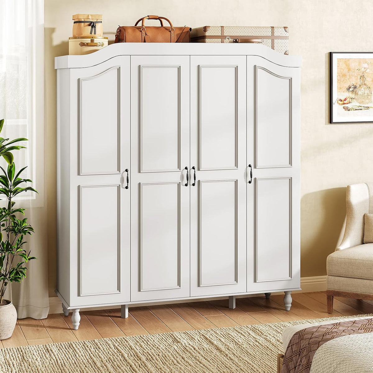Angled room view of white armoire showing arched crown and carved door panels with decor on top