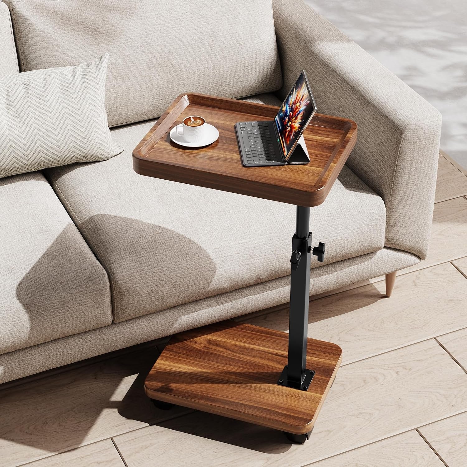 Walnut-finish C-shaped end table beside a light fabric sofa showing top and base with castor wheels