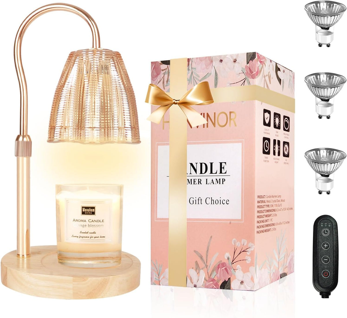 Rose-gold arched lamp with ribbed clear amber shade over a round wood base, candle, gift box and remote at right.