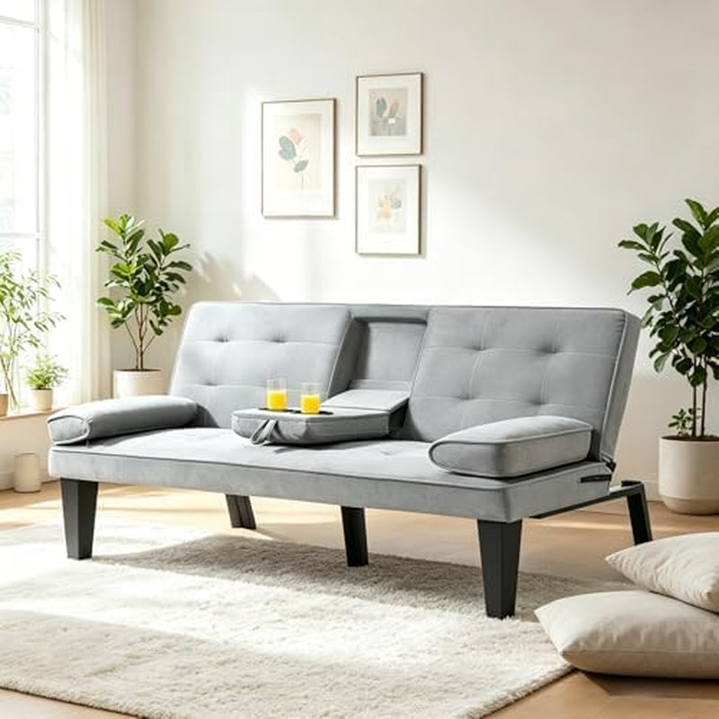 Light gray velvet convertible sofa with tufted back, arm pillows and center console in a bright living room.