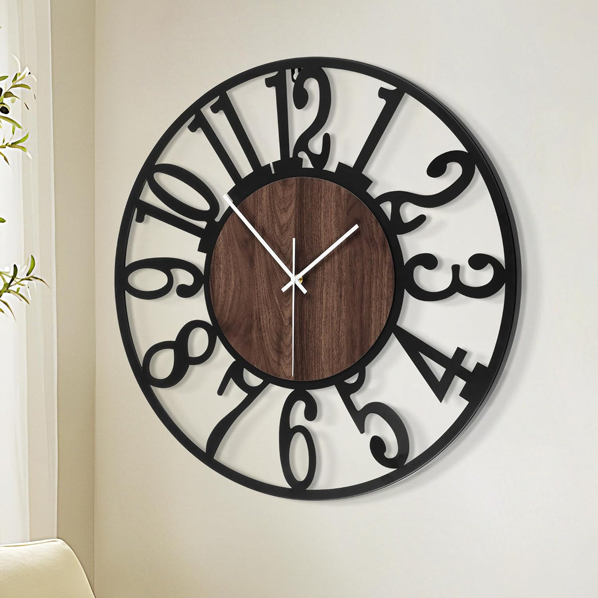 Angled detail of the clock's black cutout numerals and wood-effect MDF center with visible white second hand