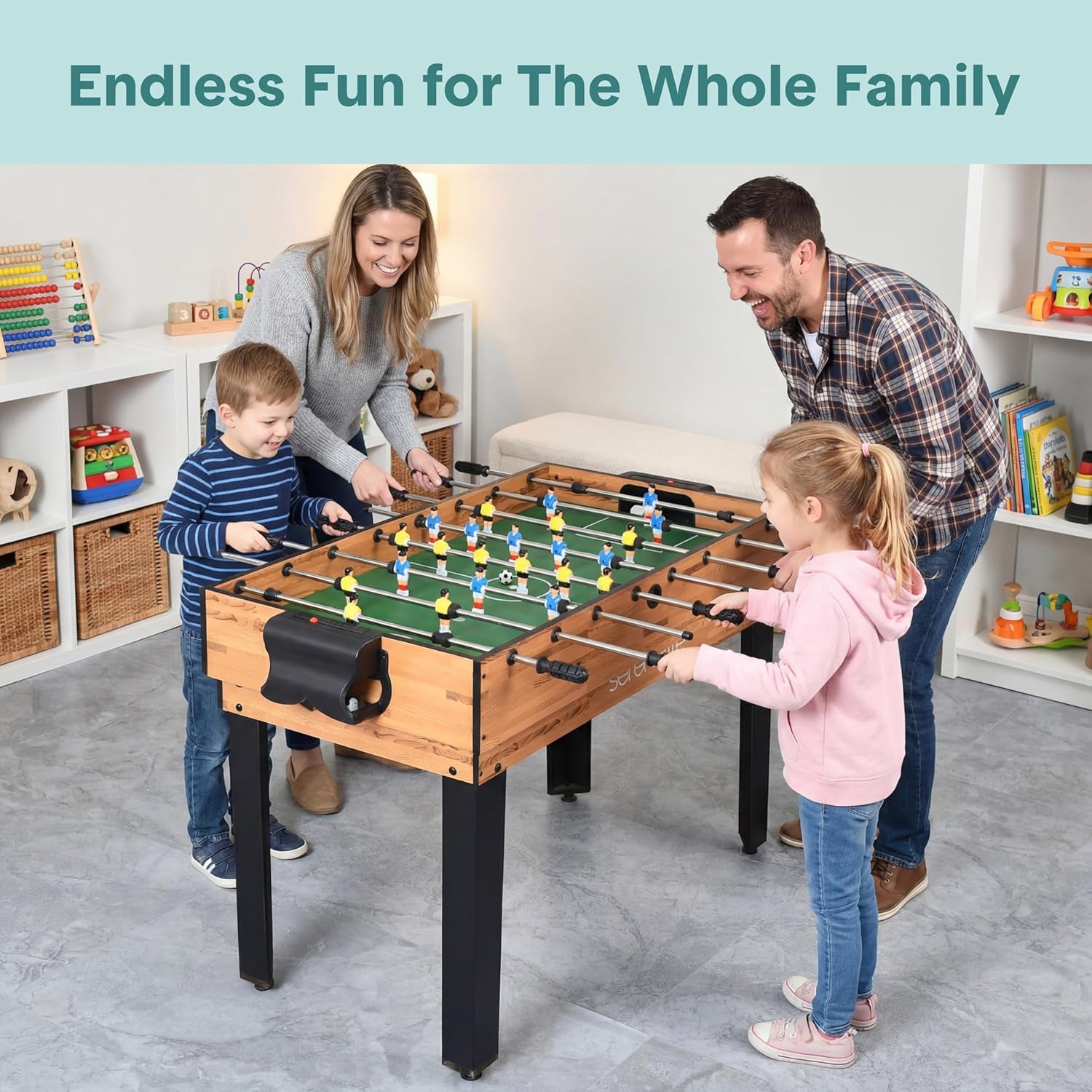 Family of four playing foosball on a wood-finish game table in a bright playroom setting