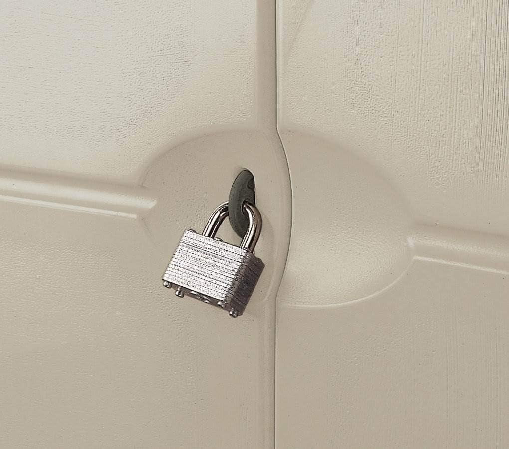 Close-up of a silver padlock secured through the shed's door hasp against a beige door