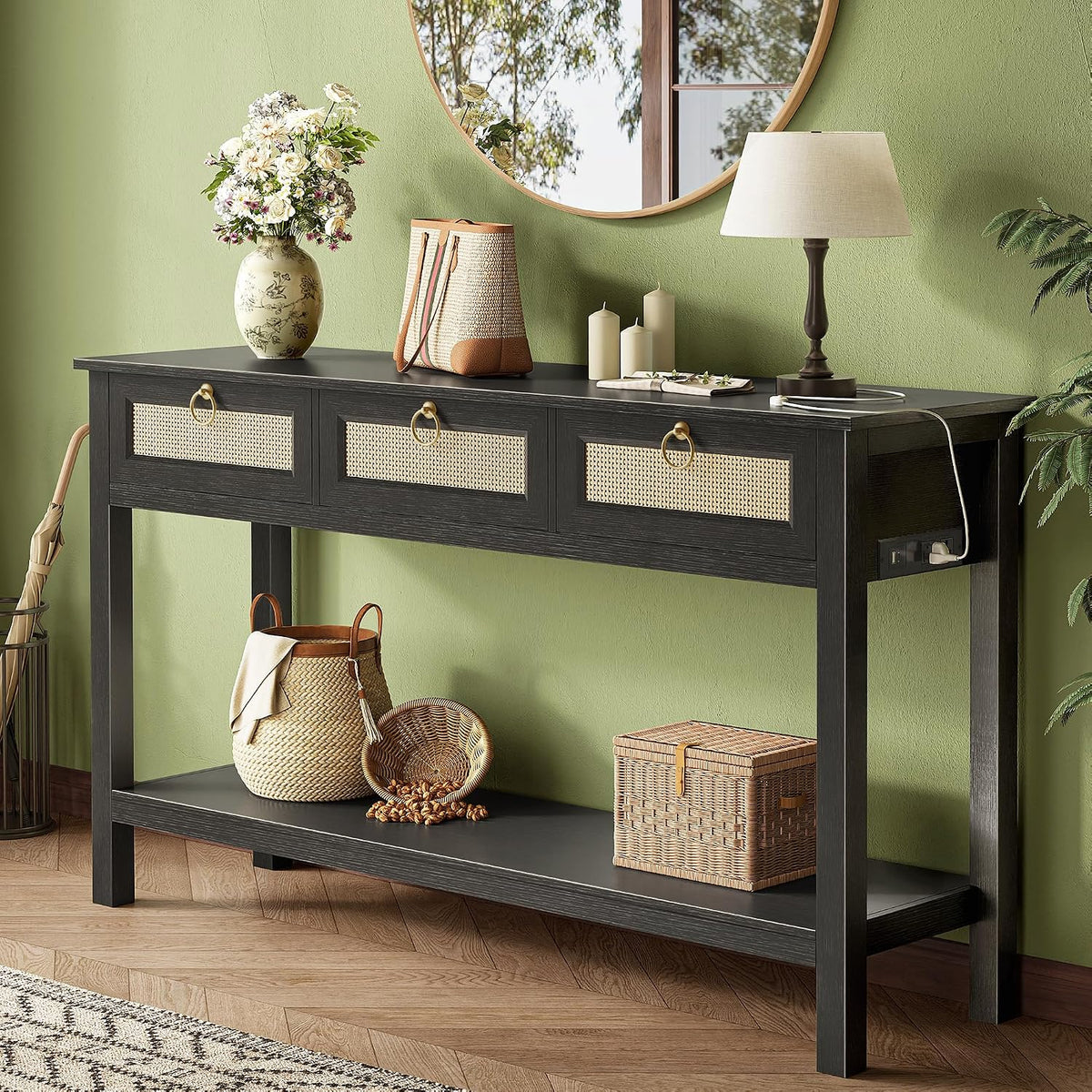 Console table in a black finish set against a green wall with decorative baskets on the shelf