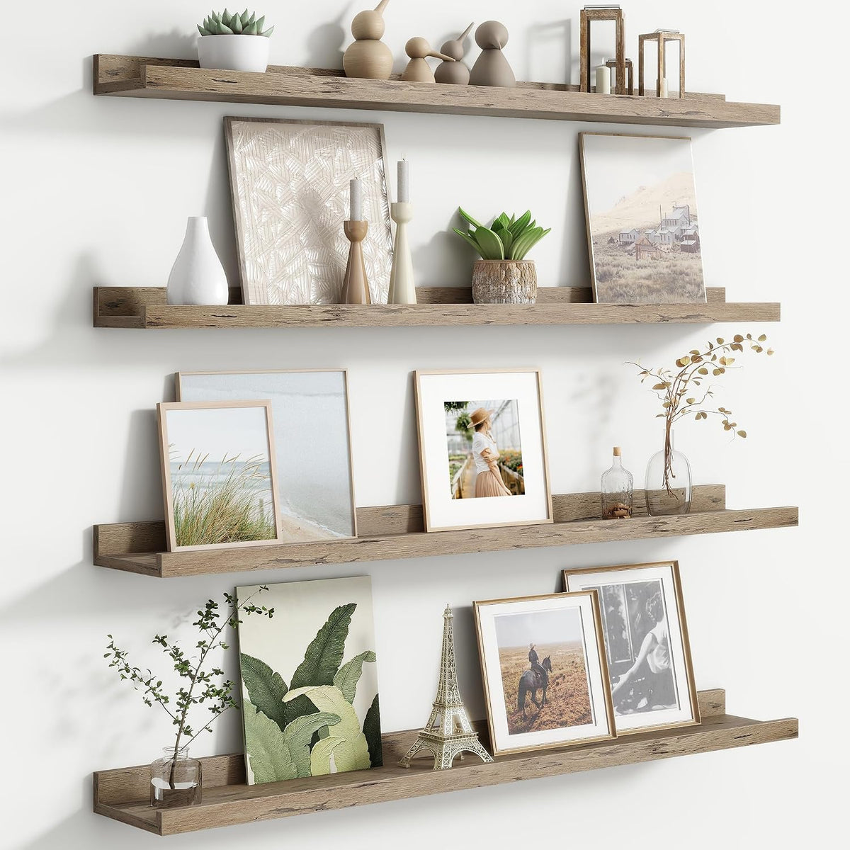Weathered gray wood ledges shown straight-on holding leaning framed art, candles and a small potted plant