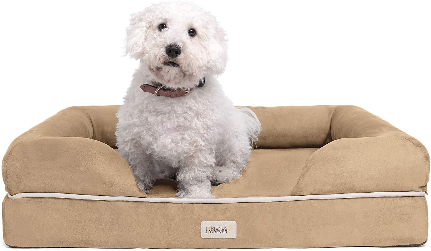 Front view of a tan bolster dog bed with a small white curly-haired dog sitting on the cushion.