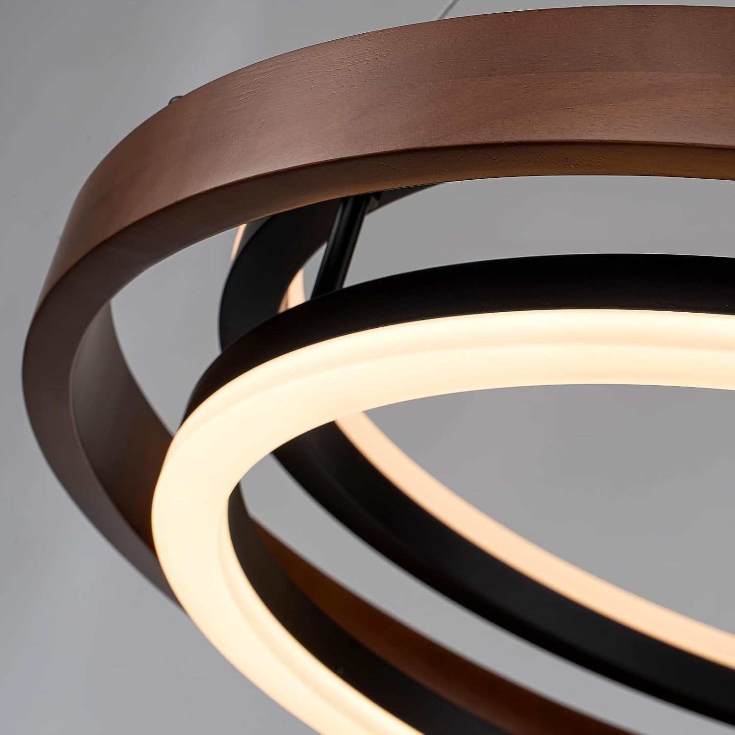 Close-up of the layered circular wooden rings and glowing LED diffuser on the pendant light