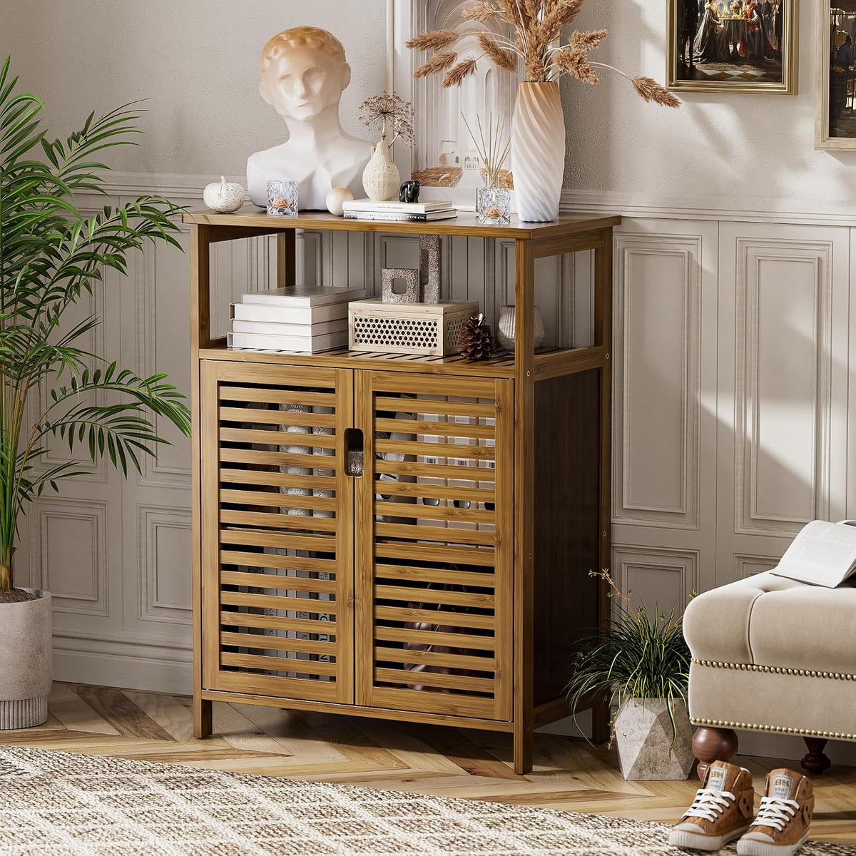 Bamboo cabinet styled in a living room with decorative vases and books arranged on the tabletop and open shelf