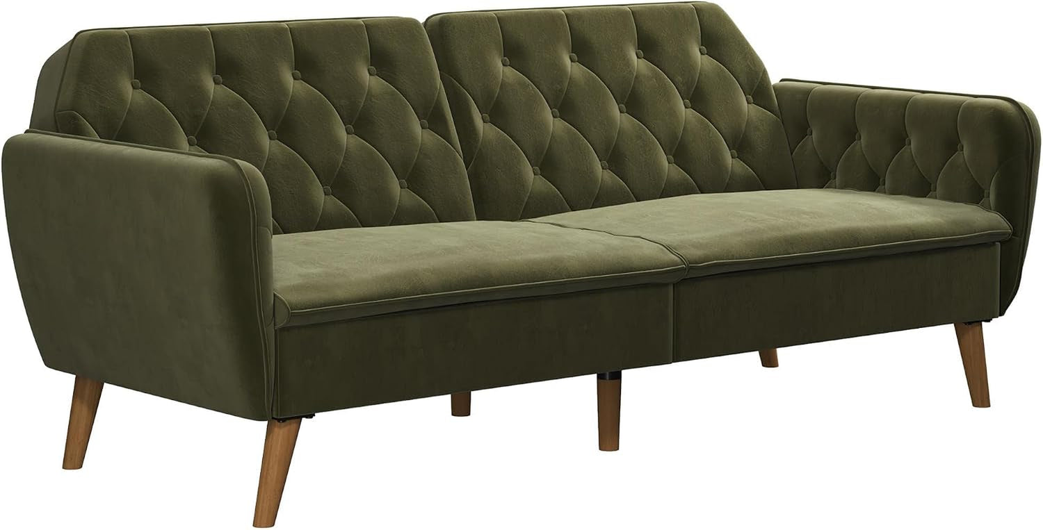 Studio-angle close view of green velvet tufted futon sofa bed with exposed wooden legs