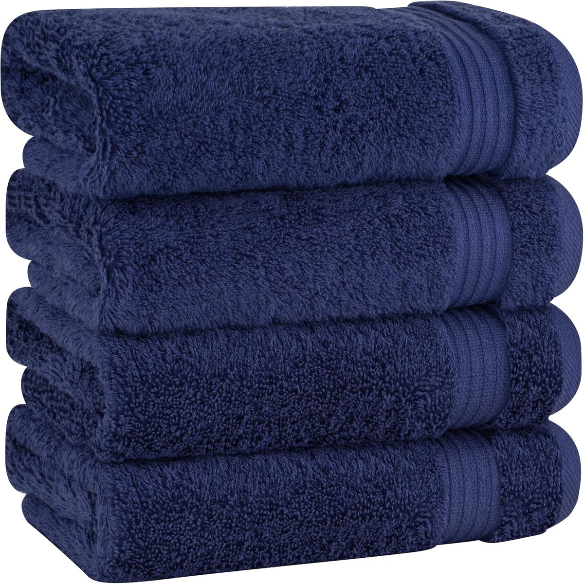 Four deep navy blue towels stacked neatly showing plush pile and ribbed border ends.