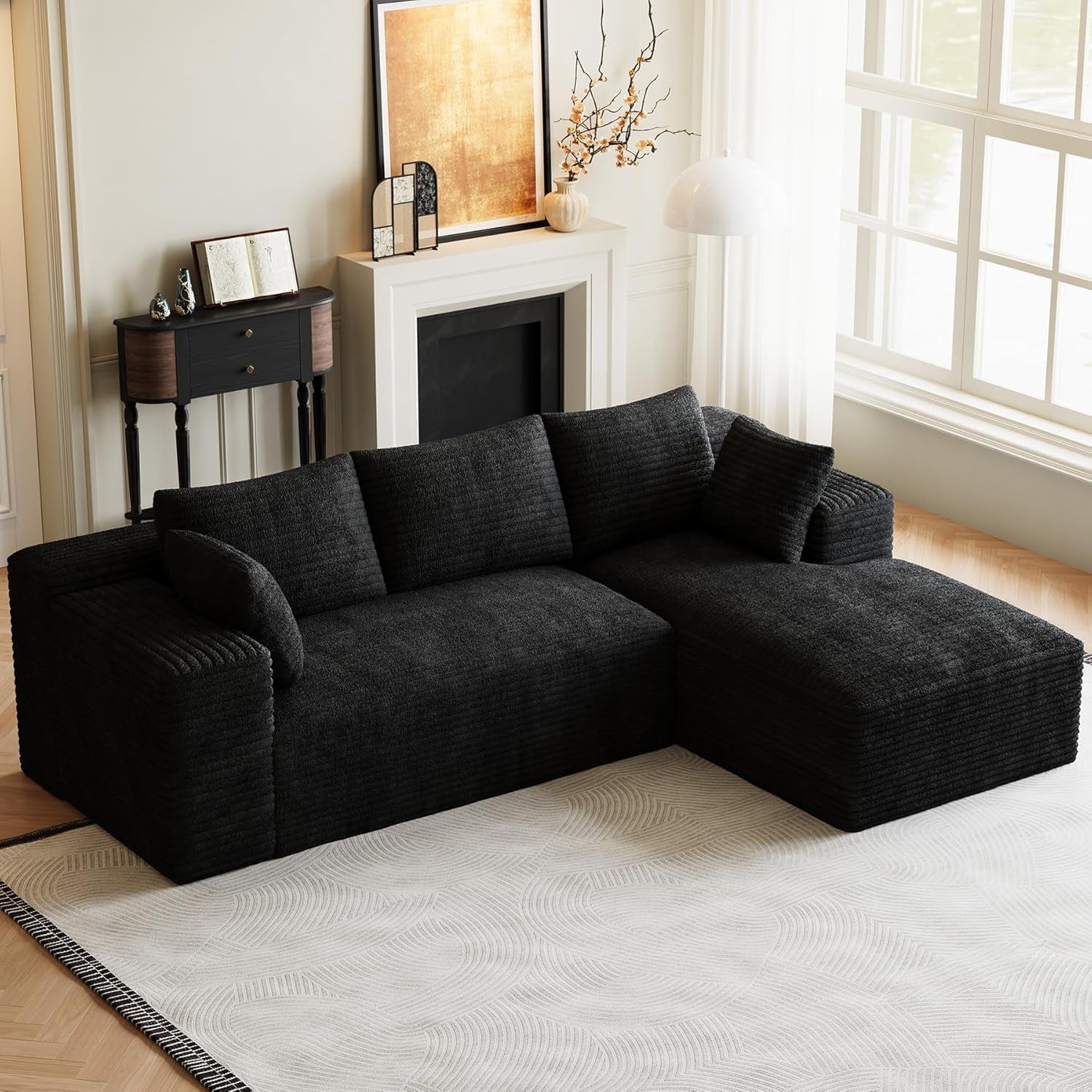 Dark charcoal L-shaped modular sectional with chaise positioned on a patterned rug