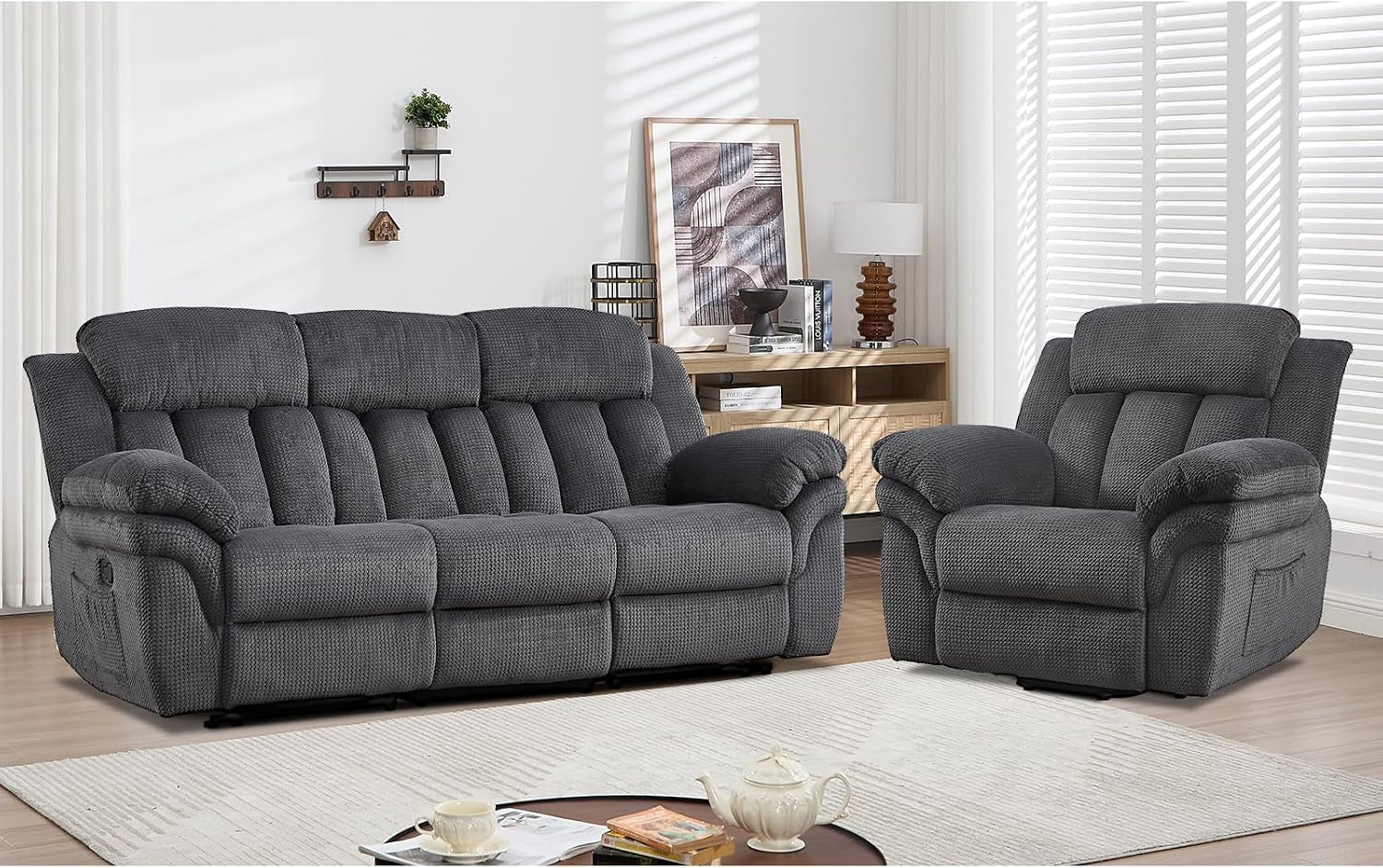 Dark gray three-seat recliner sofa with matching single recliner in staged living room.