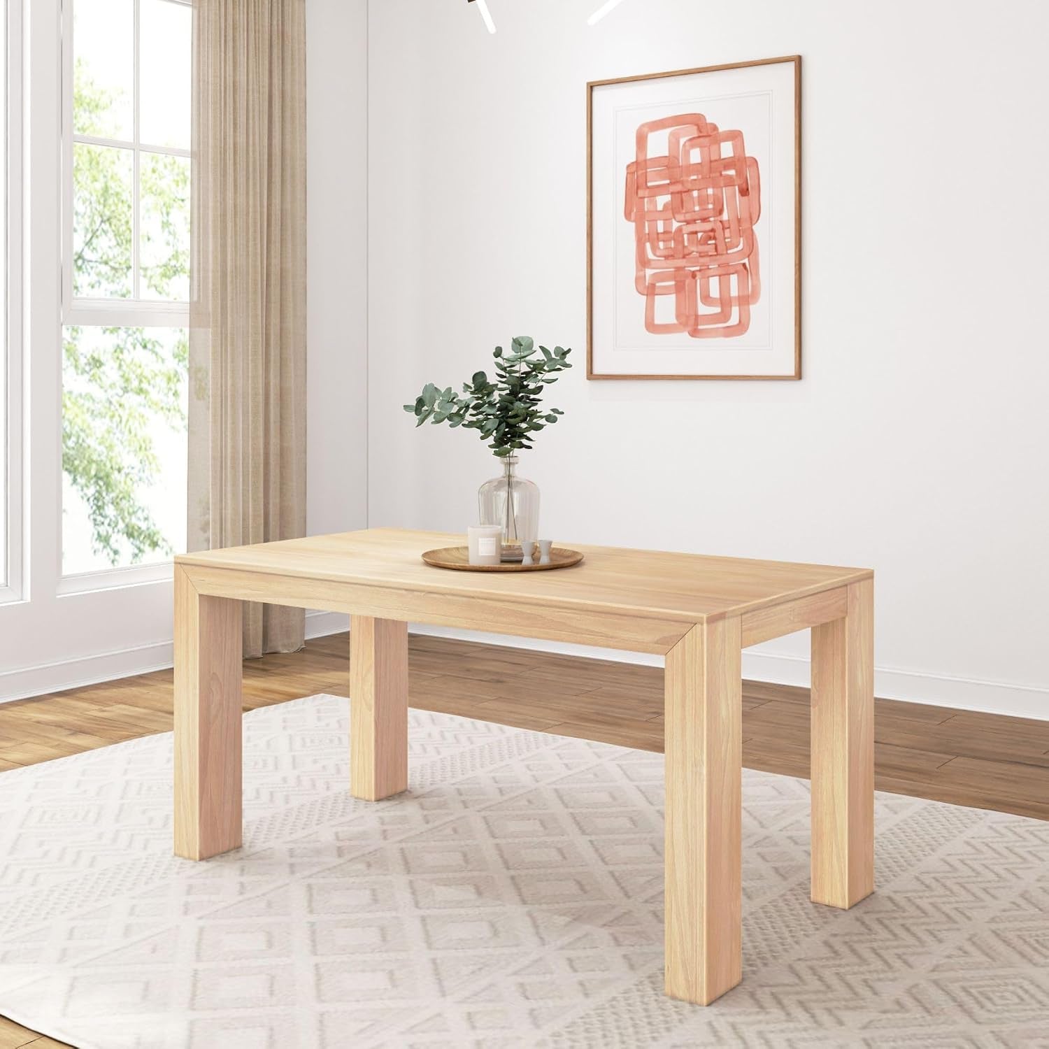 Rectangular dining table in a light natural wood finish centered on a patterned rug by a window
