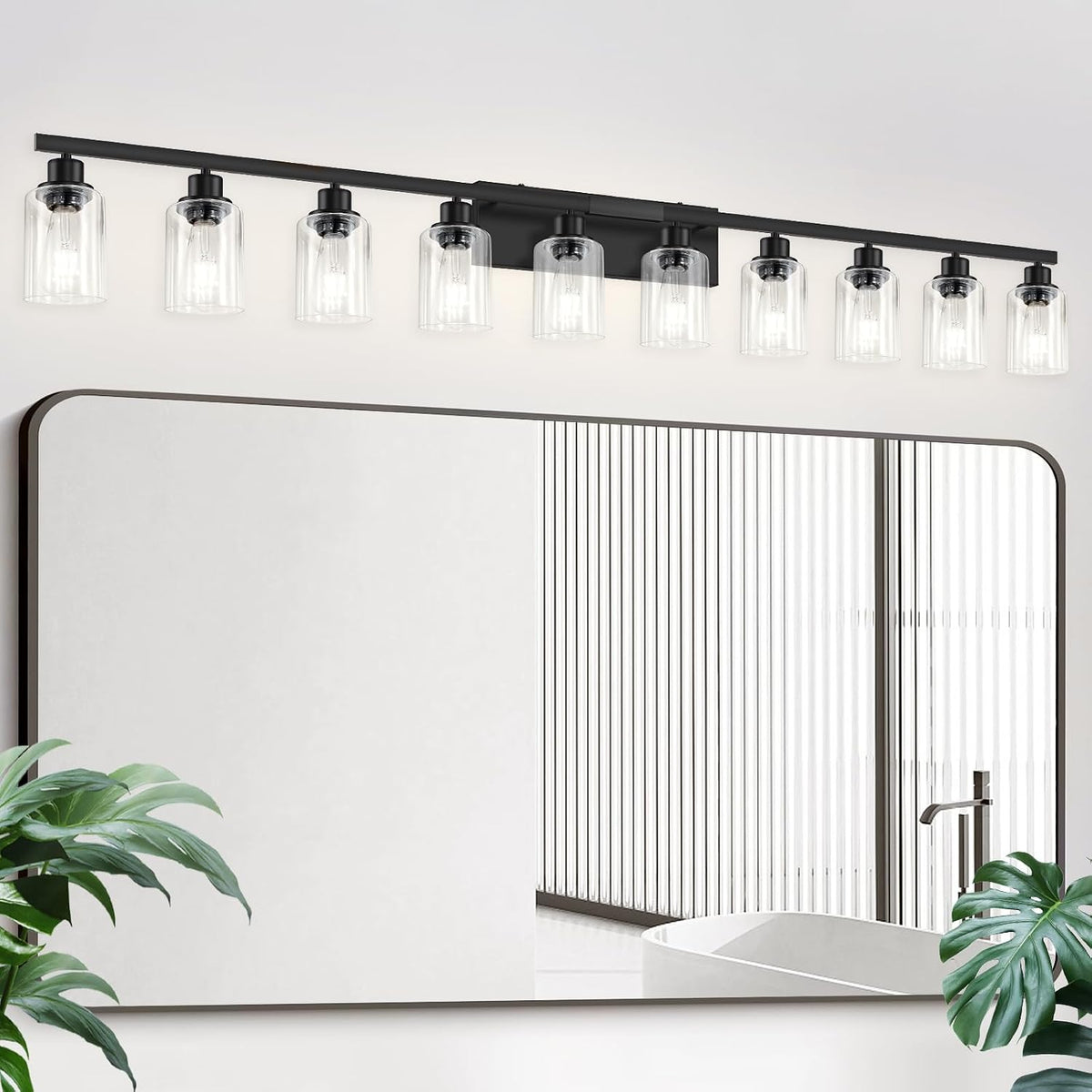 Long black vanity fixture with nine clear cylindrical glass shades reflected above a mirror