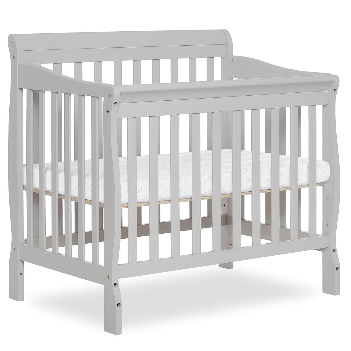 White mini crib photographed on white background showing slatted sides and mattress.