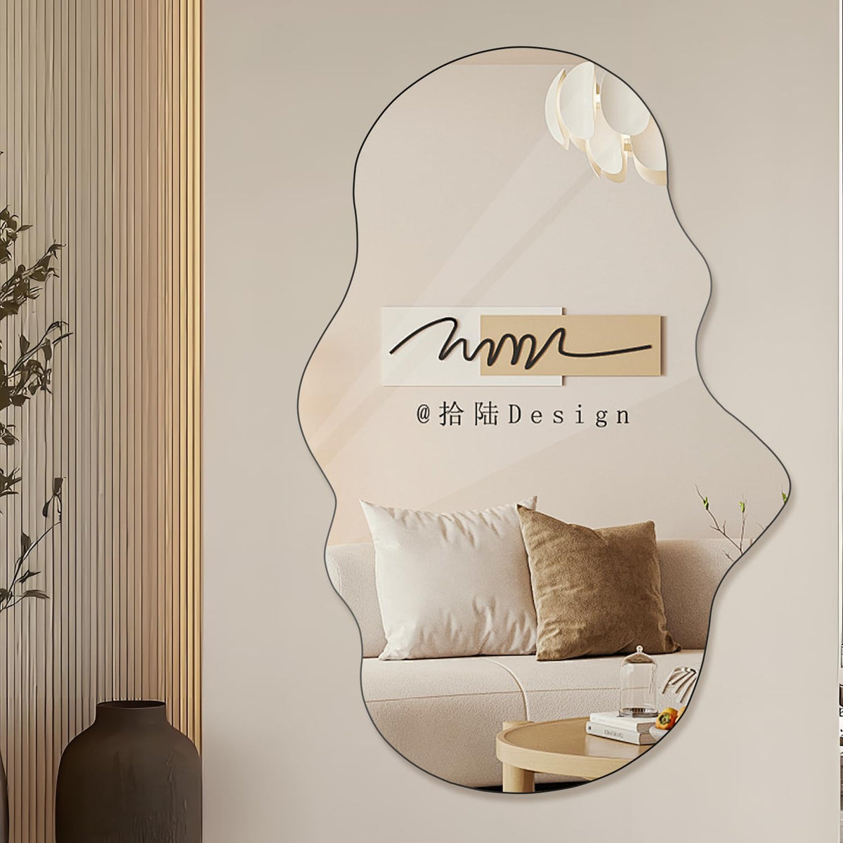 Cloud-shaped mirror with black outline mounted beside vertical ribbed panel and a dark floor vase, reflecting a sofa and