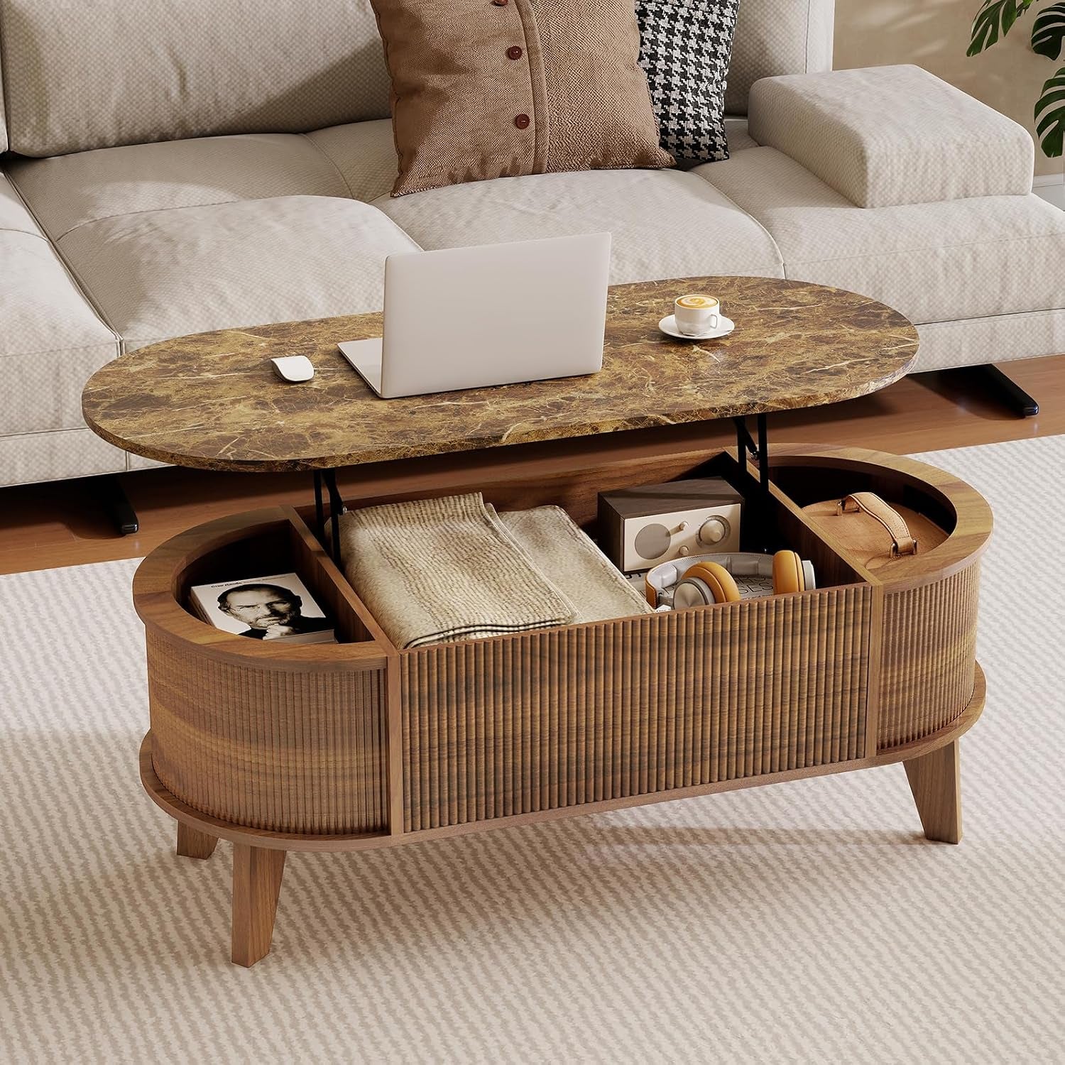 Oval walnut coffee table with lift-top open to reveal divided storage, set on a rug in front of a light sofa.