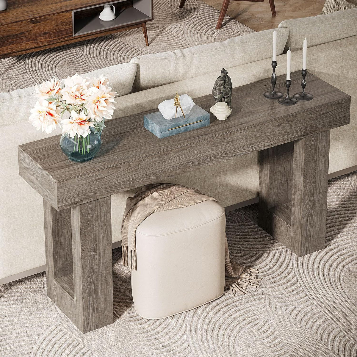 Rear/top view of grey console table placed behind a sofa with decorative objects and an ottoman nearby