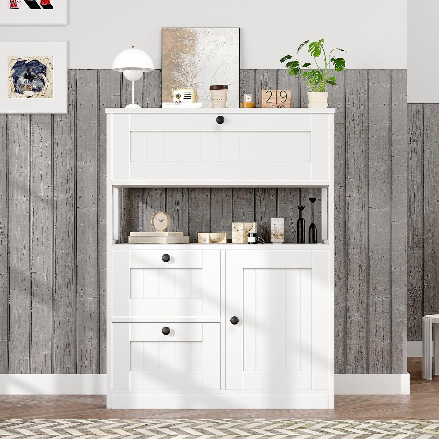 White storage cabinet staged against wood-panel half wall with decorative items on top and open middle shelf