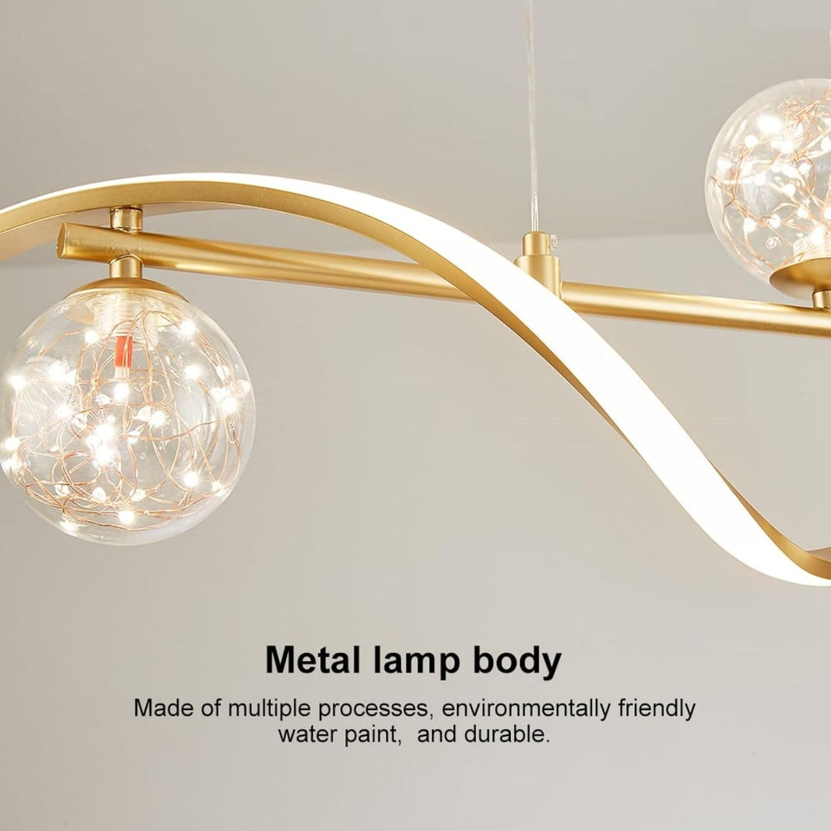 Dining room perspective of gold linear chandelier from below showing curved arms and illuminated globe shades