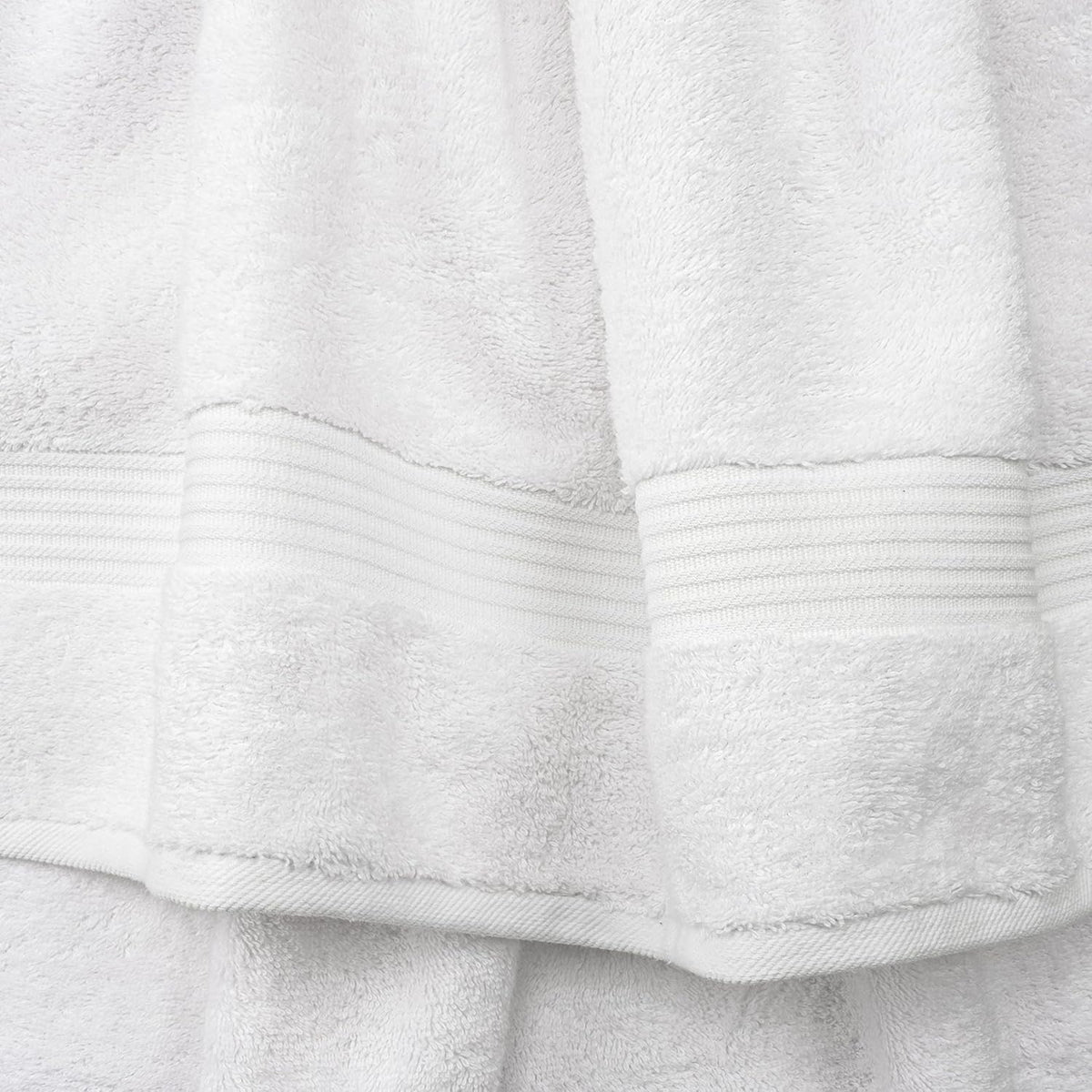 Close-up of white towel pile and textured ribbed border detail