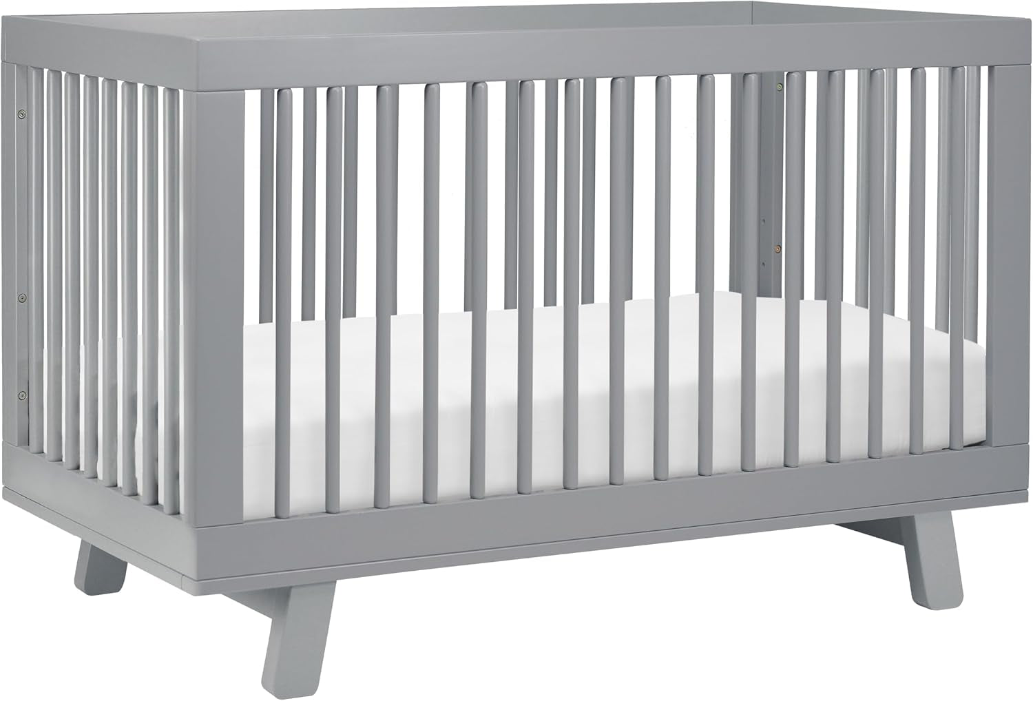 Three-quarter view of a light gray crib with rounded slats and angled legs.
