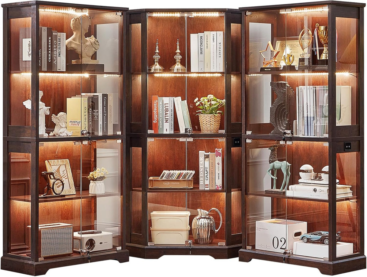 Three dark-brown glass display cabinets arranged in a slight arc, each lit and filled with books and decor