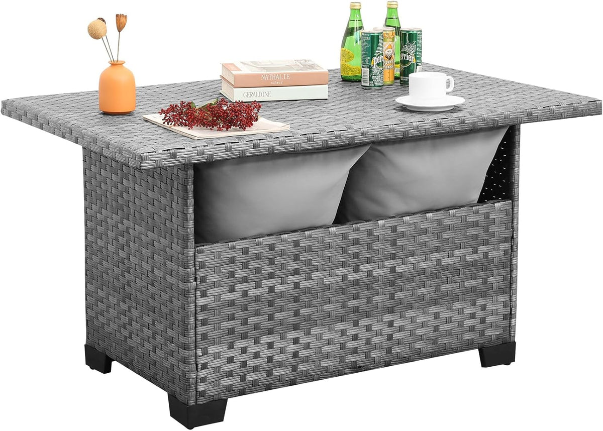 Angled three-quarter studio view of grey wicker storage table showing tabletop surface and side storage opening