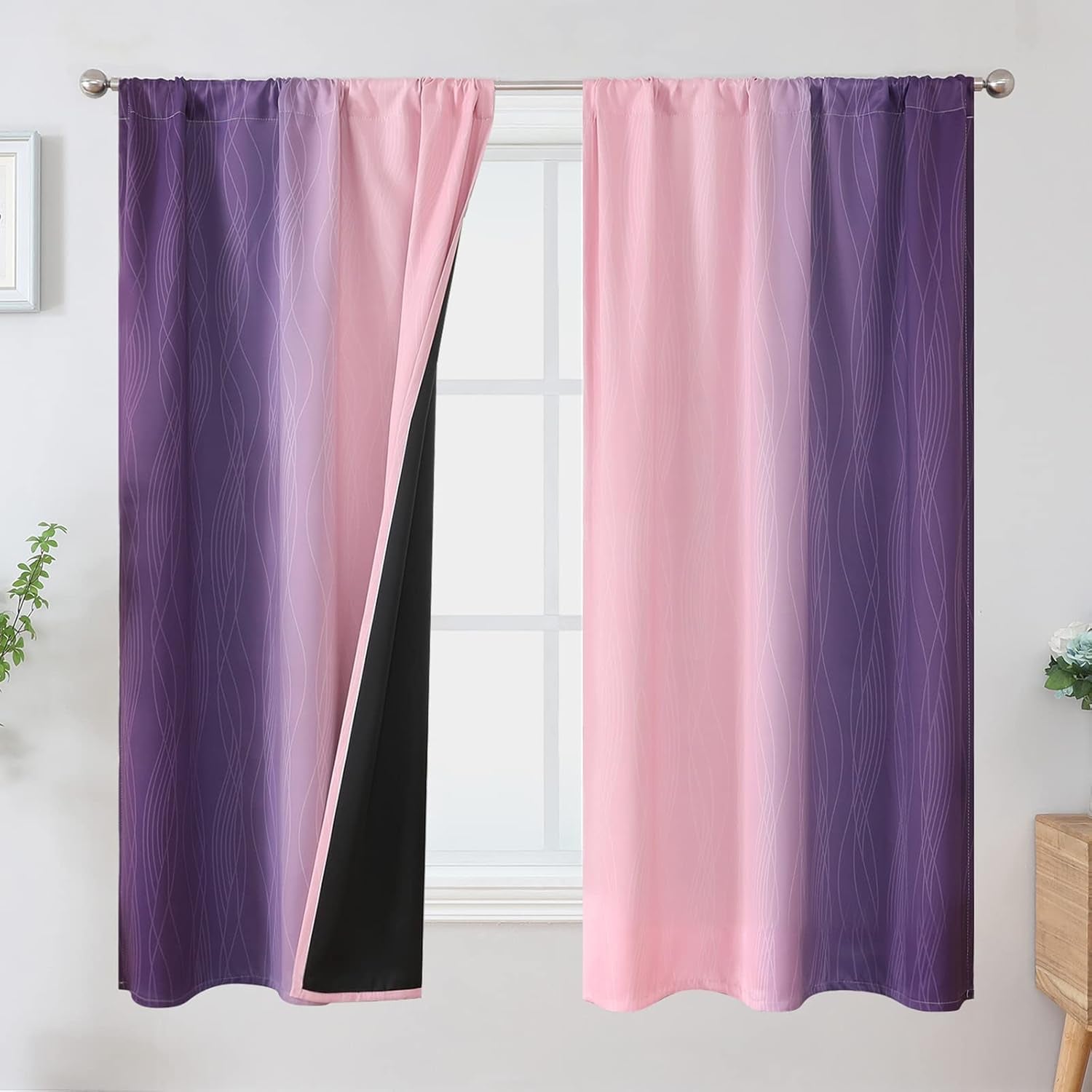 Window with pink-to-purple ombre drapes with subtle wavy lines; left panel slightly open revealing black backing.