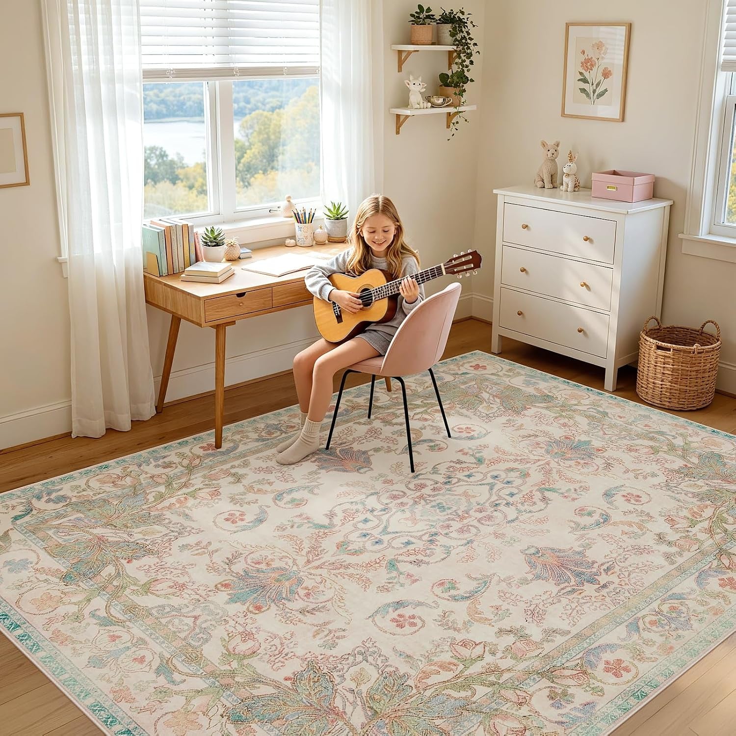 Girl sitting on a pink chair playing a guitar on a pastel floral rug in a bright study corner.