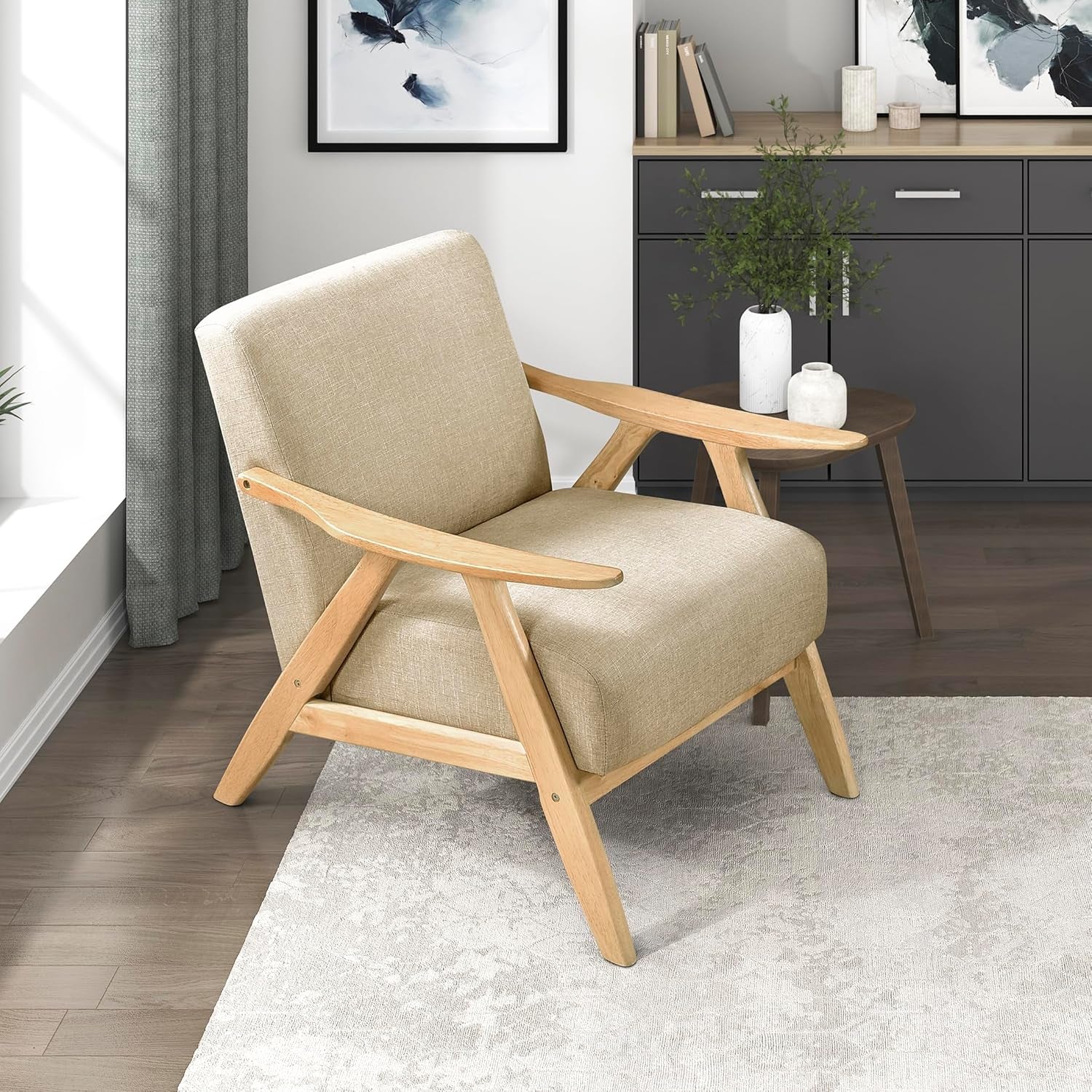 Light beige linen-look armchair with pale wood frame placed on rug beside a side table in a bright room.