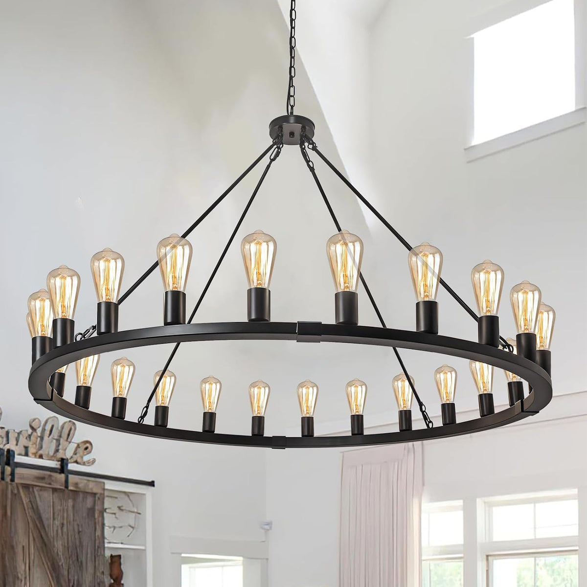 Angled view of a black metal orb chandelier with two concentric rings and many Edison-style bulbs lit