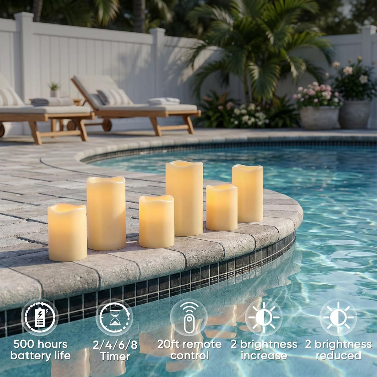 Six lit ivory resin pillar candles arranged along a pool edge in assorted heights in an outdoor daytime setting