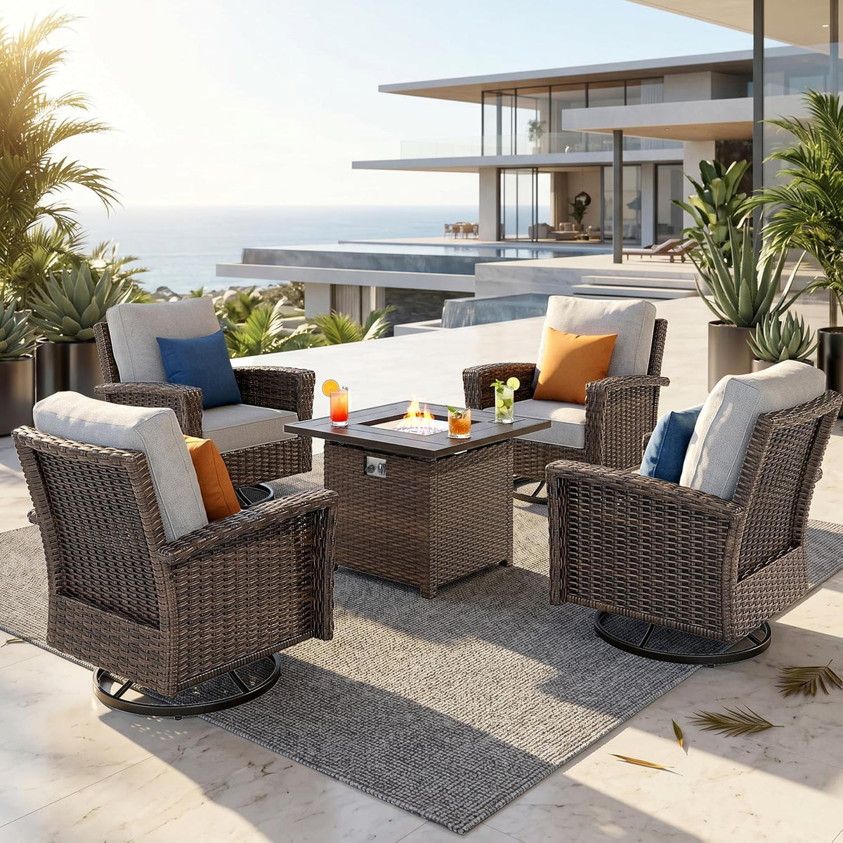 Four brown wicker swivel chairs with light gray cushions and colorful throw pillows around a square fire table on a terrace.