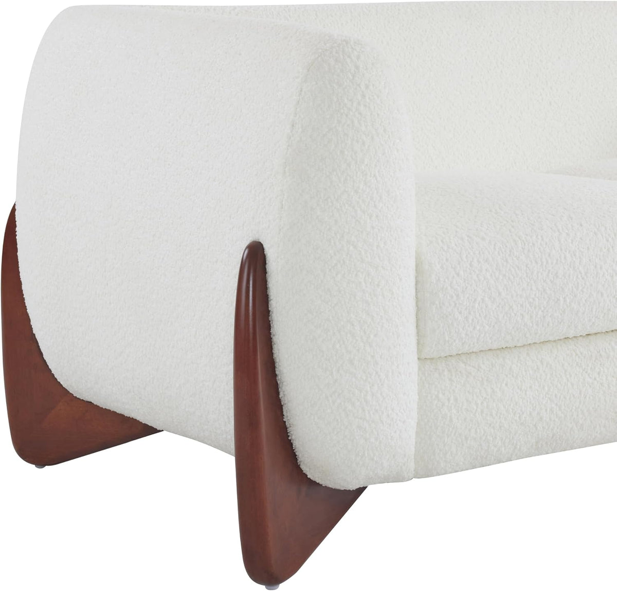Close-up of a cream boucle sofa arm and curved wood leg